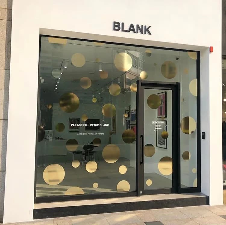 Escaparate de la galería Blank con vinilos circulares dorados
