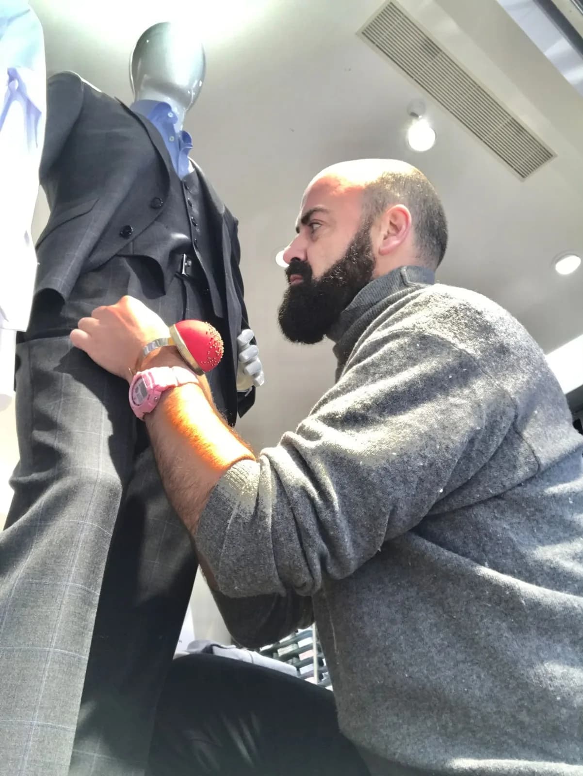 Juan Carlos Barrón ajustando el traje de un maniquí en tienda
