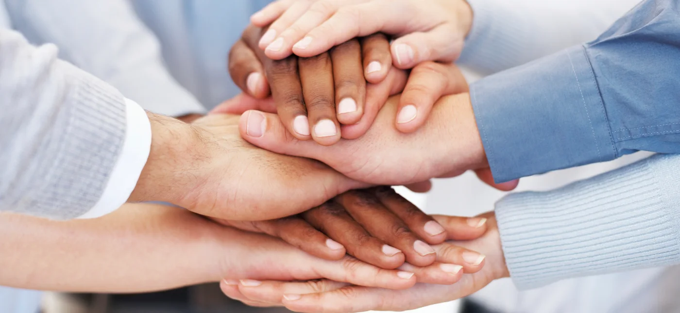 Manos de personas distintas unidas, símbolo de diversidad e inclusión